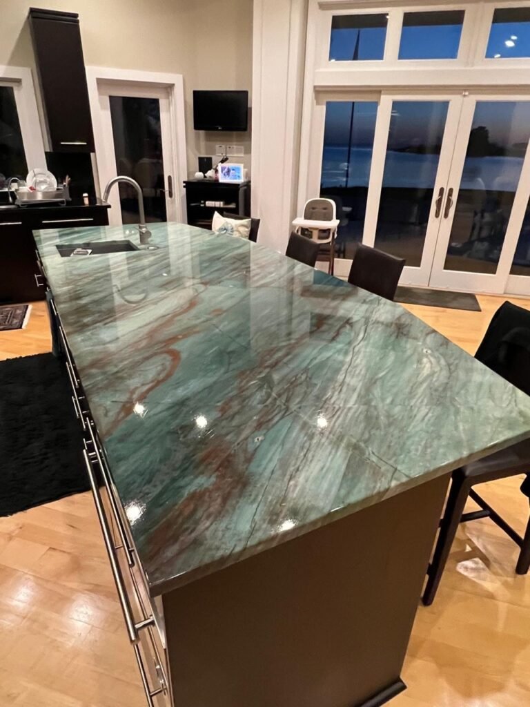 Green quartzite kitchen island with waterfront views