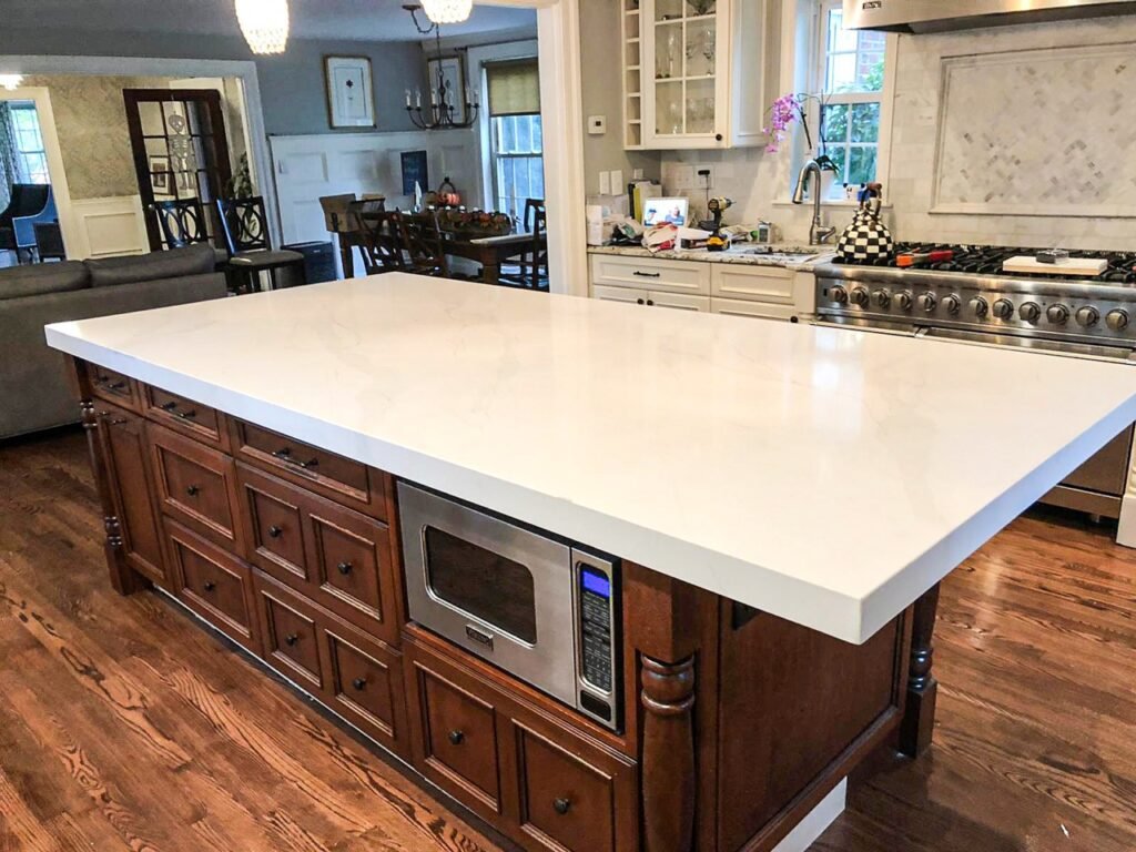 White quartz island set on dark wood cabinetry